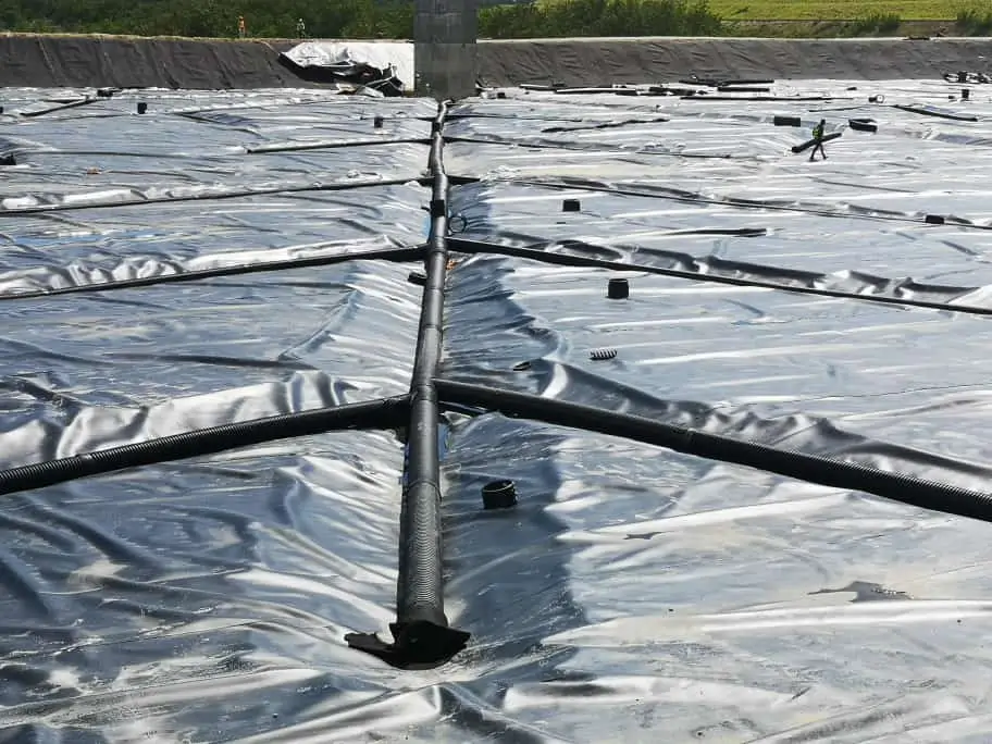 Tubería de polietileno de alta densidad sobre geomembrana de polietileno utilizada en proyectos de contención y drenaje.