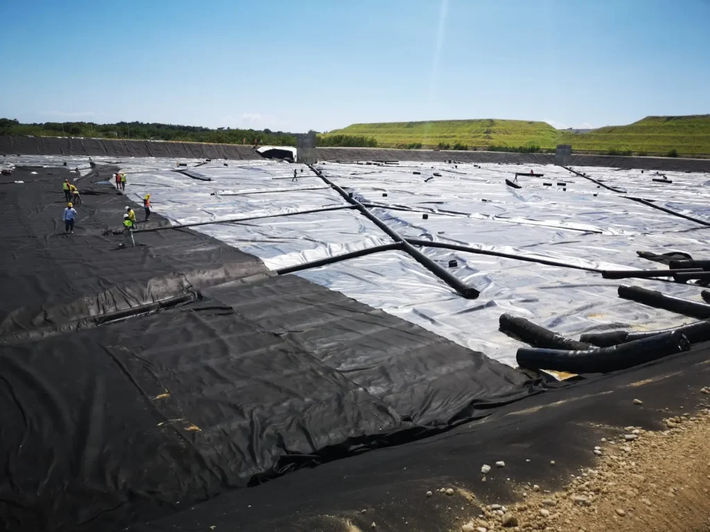 Tubería de polietileno de alta densidad sobre geomembrana de polietileno utilizada en proyectos de contención y drenaje.