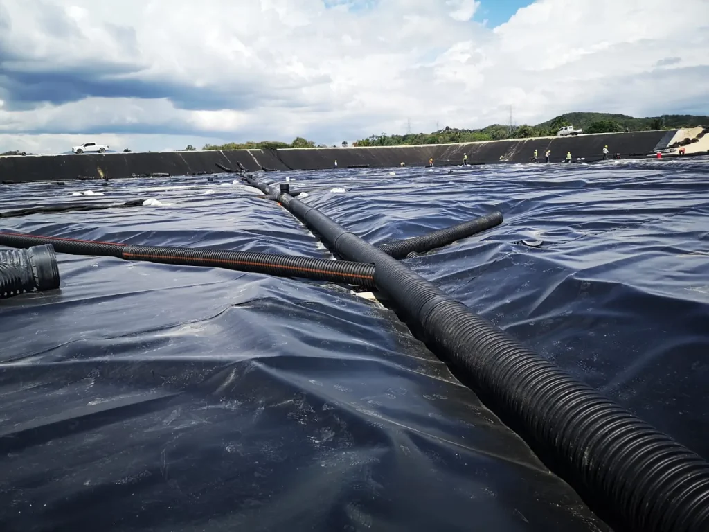 Tubería de polietileno de alta densidad sobre geomembrana de polietileno utilizada en proyectos de contención y drenaje.