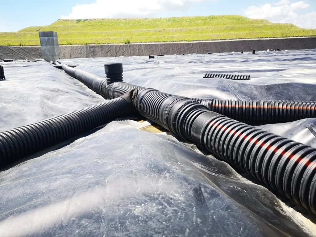 Tubería de polietileno de alta densidad sobre geomembrana de polietileno utilizada en proyectos de contención y drenaje.